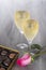 Champagne Flutes, Gourmet Chocolates, and a Pink Rose on Gray Tulle Background