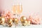 Champagne in glass goblets gold balloons stars serpentine a pastel delicate pink background. New year festive concept.