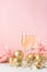 Champagne in glass goblets gold balloons stars serpentine a pastel delicate pink background. New year festive concept.