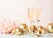 Champagne in glass goblets gold balloons stars serpentine a pastel delicate pink background. New year festive concept.