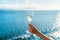 Champagne glass woman`s hand toasting on ocean background at luxury cruise ship during sunset. Travel vacation for honeymoon, lad