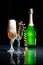 Champagne glasses and green champagne bottle lighted with grid and sidelight.