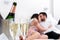 Champagne glasses with kissing couple in background