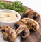 Champignon mushrooms cooked on grill with cheese sauce