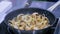 Champignon mushrooms and onions frying and sizzling in pan