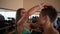 Championship backstage. Beautiful female bodybuilder in bikini helps a male bodybuilder get ready for the competition.