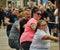 Championship in bus pulling on a thick rope with a team of three men and two young strong women with glasses