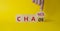 Chance vs Chaos symbol. Businessman hand points at Turned wooden cubes with words Chaos and Chance. Beautiful yellow background.