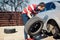 Changing a flat car tire in the backyard. Tire maintenance, damaged car tyre or changing seasonal tires