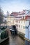 Channel Certovka and watermill near Charles Bridge in Prague under the snow in winter. View of Kampa island.