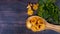 Chanterelle mushrooms in a wooden spoon, on a dark wooden background, with flowers of parsley and dill. Collecting