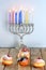 Chanukah celebration concept. Close up view of tasty donuts with jam and menorah traditional candelabra.