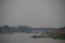 Chao Phraya River landscape in the evening fog overlooking De Chatwong Bridge, Nakhon Sawan Province, Thailand.