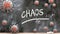 Chaos and covid virus - pandemic turmoil and Chaos pictured as corona viruses attacking a school blackboard with a written word