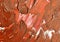 Chaotic paint strokes. Stained burgundy red  color painted wall surface . rough plaster texture. sloppy bumpy staining,