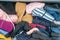 Chaotic wardrobe and sloppy closet shows many outfits of a woman with shopping addiction and many clothes like pullovers, shirts a