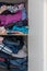 Chaotic wardrobe and sloppy closet shows many outfits of a woman with shopping addiction and many clothes like pullovers, shirts a