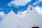 Chapel building architecture detail in Mykonos, Greece. Church bell tower and dome with crosses. White church on cloudy