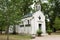 Chapel in a park with benches to sit decorated by flower