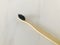 Charcoal infused bamboo toothbrush on marble white background.