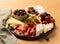 Charcuterie board with jamon, pork sausage with pepper, fuet, cheese and berries