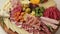 Charcuterie and cheese platter rotates smoothly around its axis. Appetizers boards with assorted cheese, salami, ham, grape and