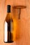 Chardonnay Bottle and Corkscrew on Wood Background