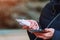 Charger in the female hand of a tourist with a discharged smartphone lifestyle outdoors. Selective focus on charging