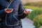 Charger in the female hand of a tourist with a discharged smartphone lifestyle outdoors. Selective focus on charging