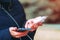 Charger in the female hand of a tourist with a discharged smartphone lifestyle outdoors. Selective focus on charging