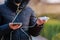 Charger in the female hand of a tourist with a discharged smartphone lifestyle outdoors. Selective focus on charging