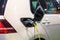 Charging an electric or hybrid PHEV car with the power cable supply plugged in. Electric car charging station.