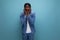 charismatic dude african man with curly hair in a denim jacket on a blue background