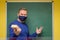 Charismatic male teacher smiling behind face mask