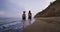 Charismatic sporty ladies running together on the beach through the water in the morning enjoying the time together