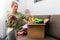 Charity - woman sorting clothes and put into the cardboad box for donation