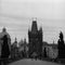 Charles bridge in Prague with two people walking early in the morning