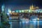 Charles bridge and Vltava river at night with blurred boat movement, Prague