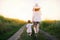 Charming, adorable and amazing view of walking of a pretty mother and beautiful little daughter on a path field. Motherhood and