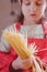 Charming adorable attractive beautiful caucasian child girl chef having fun and praparing vermicelli. Cooking process and food