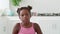 Charming adorable child, African American baby girl with two ponytails, wearing a bright pink top confidently looking at
