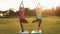 Charming adult women standing in yoga tree pose