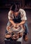 Charming artisan girl sculptor works with clay on a Potter`s wheel and at the table with the tools. Handicraft industry.