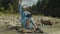 Charming asian biologist woman with tablet pc working on water analysis on mountain river