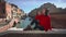 Charming asian woman sitting on a bridge engoying the warm weather and basking in the sun during her Italy vacation