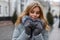 Charming attractive young woman blonde in stylish warm winter outerwear in knitted mittens enjoys the weekend.