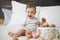 Charming baby girl with easter basket of eggs