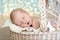 Charming baby, sleeping wicker stroller, close-up