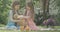 Charming beautiful twin sisters playing with teddy bear and toy rabbit outdoors. Portrait of Caucasian girls resting on