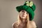 Charming blond girl in image of leprechaun with air kiss gesture